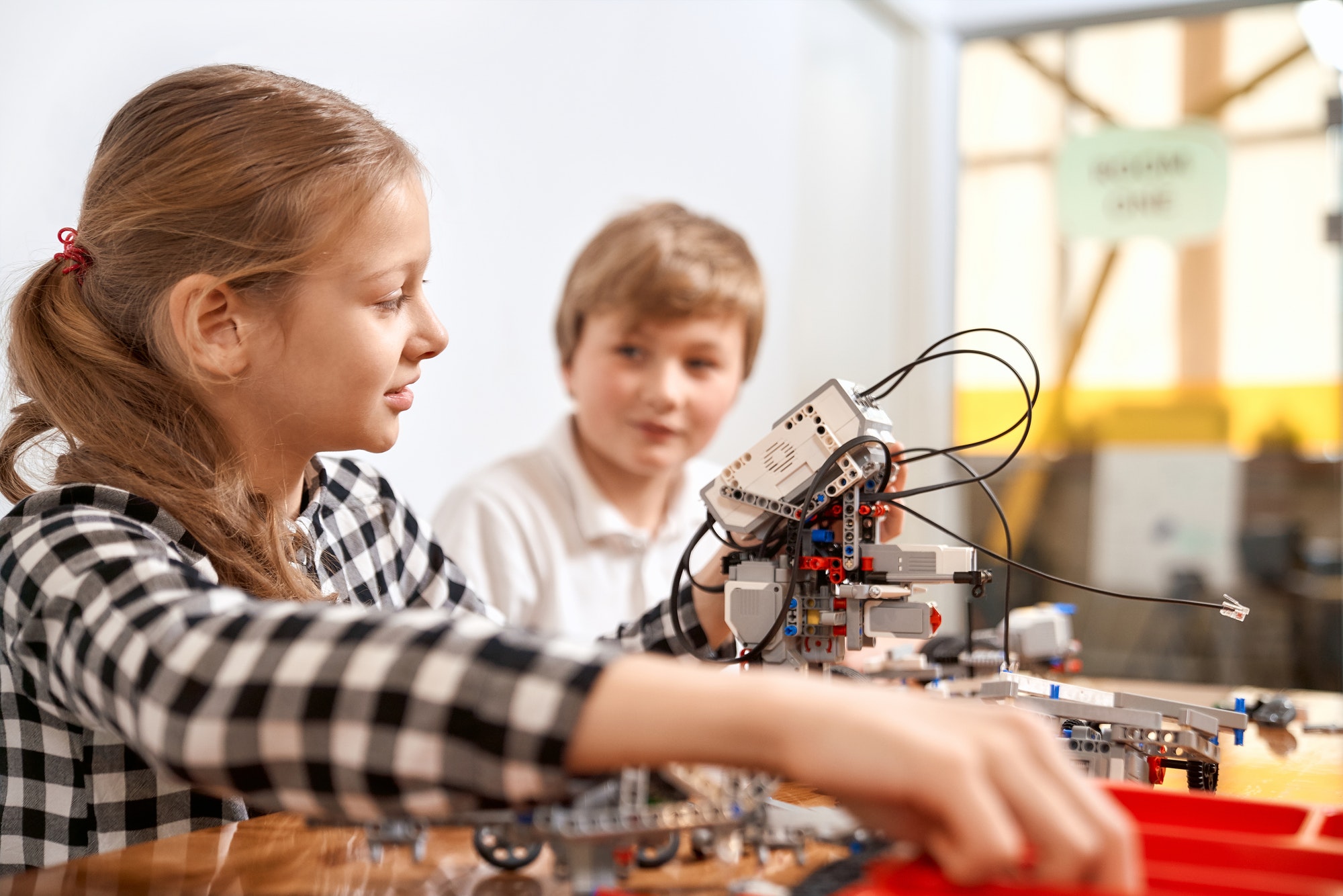 boy and girl creating robot using building kit